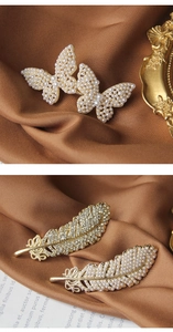 Close-up of golden rhinestone hair clips with pearls on silk, butterfly and feather designs