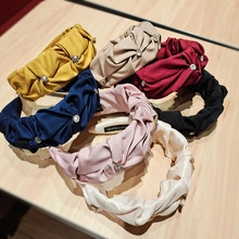 Nahaufnahme von plissierten Satin-Stirnbändern mit Perlen in verschiedenen Farben