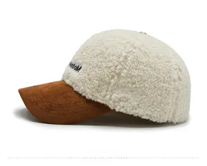 Detail of warm off-white lamb wool baseball cap with brown brim and side letter patch
