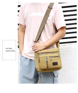 Detail of khaki canvas crossbody bag with multiple zipper pockets and adjustable strap