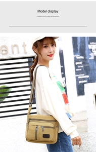 Canvas shoulder bag detail showing multiple zip pockets and adjustable strap in khaki color