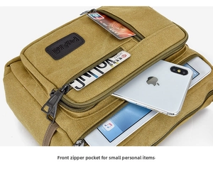 Detail view of khaki canvas crossbody bag with multiple zip compartments and storage slots