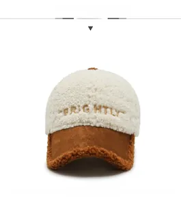 Dettaglio del cappello da baseball in lana di agnello con ricamo dorato e visiera marrone