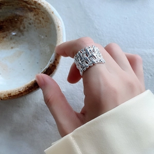 Macro detail of 925 sterling silver woven ring featuring a wide band braided texture design