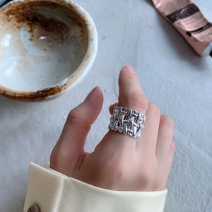 Detailed view of 925 sterling silver woven ring with a hollow cross pattern on hand