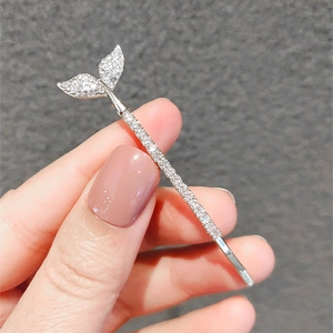 Macro detail of fish tail hair clip with silver metal and sparkling crystals