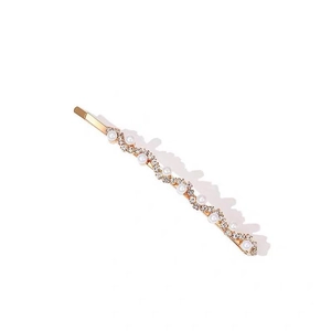 Detail of a wavy gold hair clip featuring white pearls and sparkling clear rhinestones
