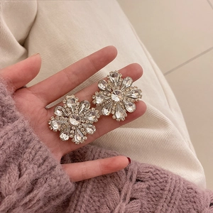 Macro shot of large sparkling crystal flower earrings with gold-toned metal plating
