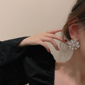 Detailed view of oversized crystal flower earrings featuring sparkling rhinestones