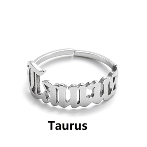 Detailed shot of silver Taurus zodiac ring featuring gothic lettering and open adjustable band