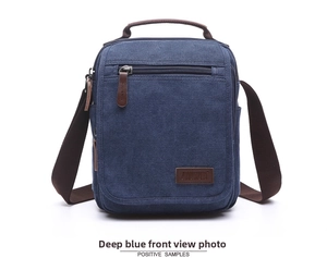 Deep blue canvas messenger bag detail featuring multiple zipper pockets and brown accents