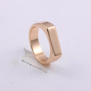 Detail view of a rose gold rectangular metal ring with a smooth polished surface and minimalist design