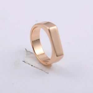 Detailed close-up of a rose gold rectangular signet ring with a minimalist flat surface