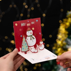 3D Christmas greeting card featuring snowman and tree in festive red and white popup design