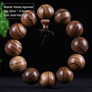 Detail of 20mm Vietnam Agarwood beads showing natural wood grain and small hole finish