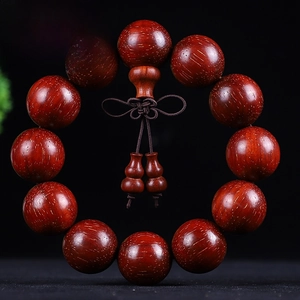 Detail of 20mm Brazilian Rosewood beads with gold fleck texture and decorative knot