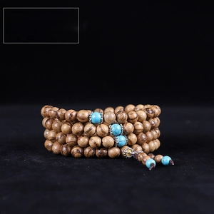 Macro view of 6mm Vietnam Agarwood 108 beads bracelet with turquoise spacer accents