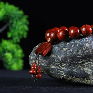 Polished Brazilian Rosewood beaded bracelet with wood plaque and gourd charms on stone