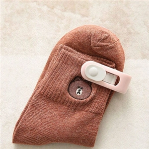 Brown knitted socks featuring cute bear embroidery held by a secure plastic fastener clip