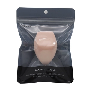 Detailed view of pink makeup sponge in transparent retail packaging with brand logo