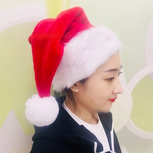 Close-up of a red and white plush Christmas hat with soft faux fur trim and pompom