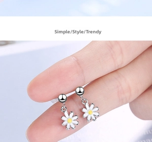Detailed close-up of small daisy drop earrings with white petals and yellow centers