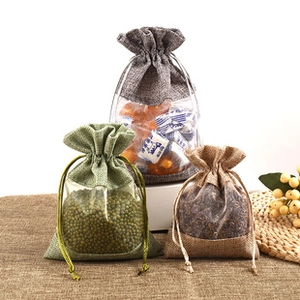 Detail of drawstring organza bags with clear windows and linen fabric textures