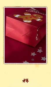 Detail showing the reinforced folded bottom of a red Christmas gingerbread gift bag