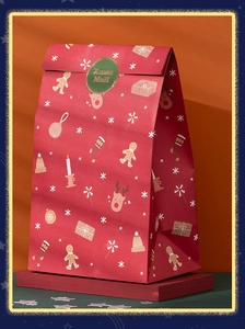 Detailed view of red Christmas paper gift bag with Xmas Mail seal on a green surface