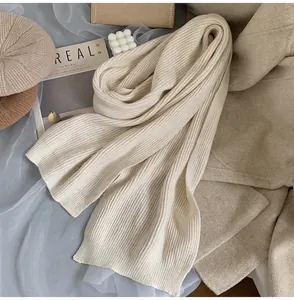 Detailed texture of off-white chunky knit scarf with classic vertical ribbed pattern