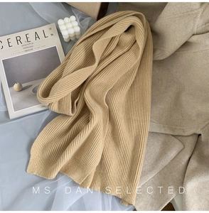 Detailed texture of beige vertical rib knit scarf with soft and thick autumn aesthetic