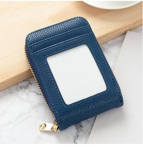 Close-up of navy blue lychee grain leather card holder with gold zipper and ID window