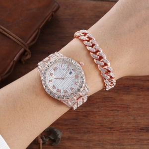 Close-up of rose gold iced-out watch and Cuban bracelet set with shimmering crystals