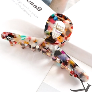 Detailed close-up of marble acetate hair claw clip with strong metal spring mechanism