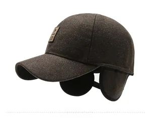 Detail view of winter brown wool baseball cap with flip-down earflaps and leather patch
