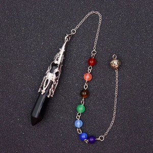 Detailed macro view of black hexagonal crystal pendulum with seven chakra colored beads