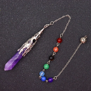 Detailed view of purple hexagonal crystal pendulum with silver filigree and chakra beads