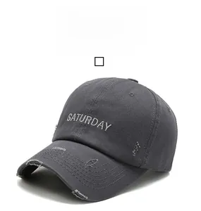 Gros plan sur la broderie SATURDAY et les détails vieillis de la casquette en coton lavé