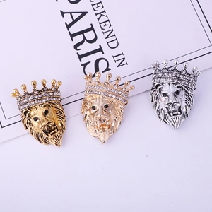 Macro detail of lion head brooches with crown in gold and silver finish on white background