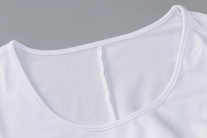 Close-up of white bodysuit neckline showing fleece lining and fine stitching detail