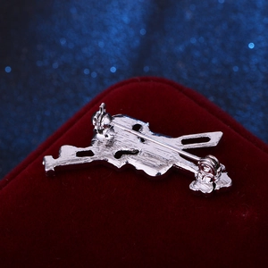 Broche violon note de musique en argent poli sur un fond élégant en velours rouge