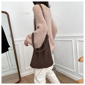 Detalle del bolso tote trenzado marrón oscuro de gran capacidad llevado al hombro