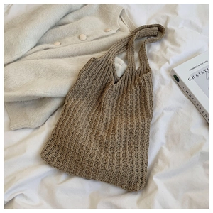 Primer plano detallado del bolso tote de punto marrón con textura de rayas en tela
