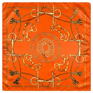 Detalle de bufanda de seda naranja con motivos de bocado y borlas doradas de lujo