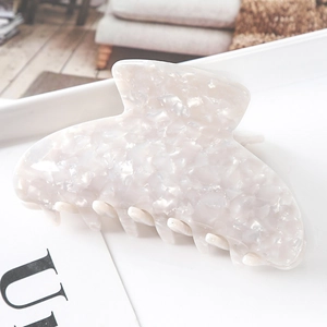 Detailed view of cream acetate hair claw clip with pearlescent marble texture for women