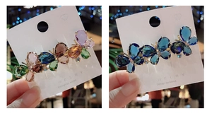 Detailed comparison of colorful and gradient blue crystal butterfly hair clips in hand