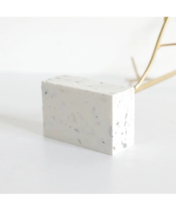 Close-up of minimalist white terrazzo base with natural gray and black stone textures