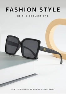 Macro detail of black square frame sunglasses with golden logo and quilted temple texture