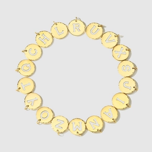 Macro view of round gold stainless steel alphabet pendants for DIY jewelry design