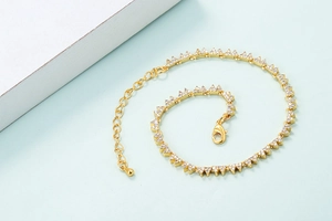 Close-up of gold geometric triangle chain bracelet with micro-pave white zircon stones